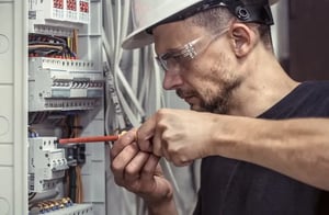Field service technician checking control wiring in an MV drive panel